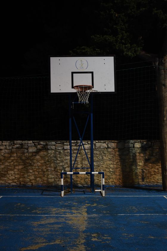 Floodlit outdoor basketball hoop at night — photo by Antoine Maurin on Pexels