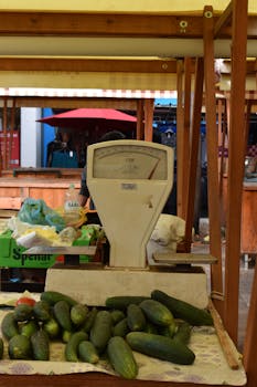 Old-fashioned market stall with cucumbers and vintage scale, ideal for grocery themes.