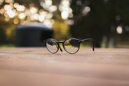 Black Framed Eyeglasses on Brown Wooden Surface 