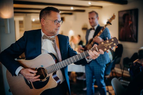 Man in Blue Suit Playing an Acoustic Guitar