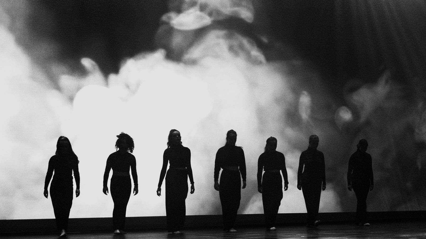 Figures silhouetted against white smoke, monochrome feed
