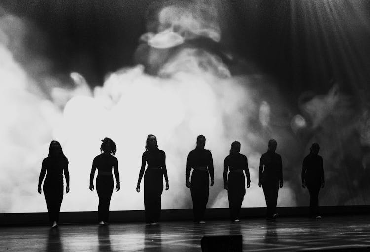 People Posing On Stage In Black And White