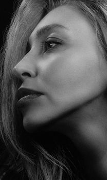 Striking side profile portrait of a young woman in black and white.