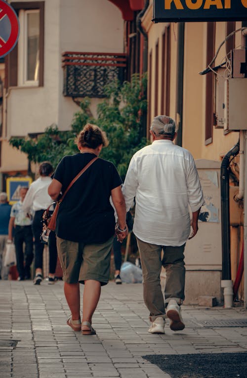 Back View of Two People Walking on the Sidewalk