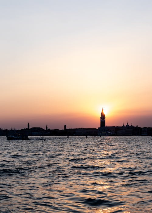 Silhouette of Buildings Near the Ocean during Sunset