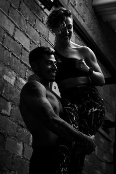 Athletic man and woman posing energetically in black and white photography.