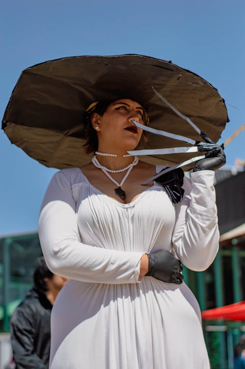 Portrait of Woman in Hat and White Dress Holding Knives