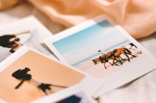 Free Close-up of nostalgic Polaroid photos depicting beach scenes and summer vibes. Stock Photo