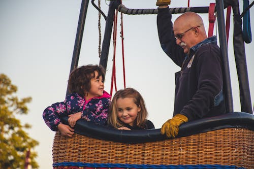 Free Man and Two Girls Riding on Hot Air Balloon Stock Photo