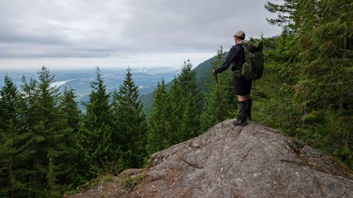 Man Standing on Top of a Rock