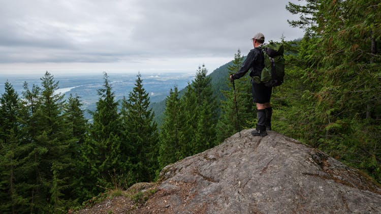 Man Standing On Top Of A Rock