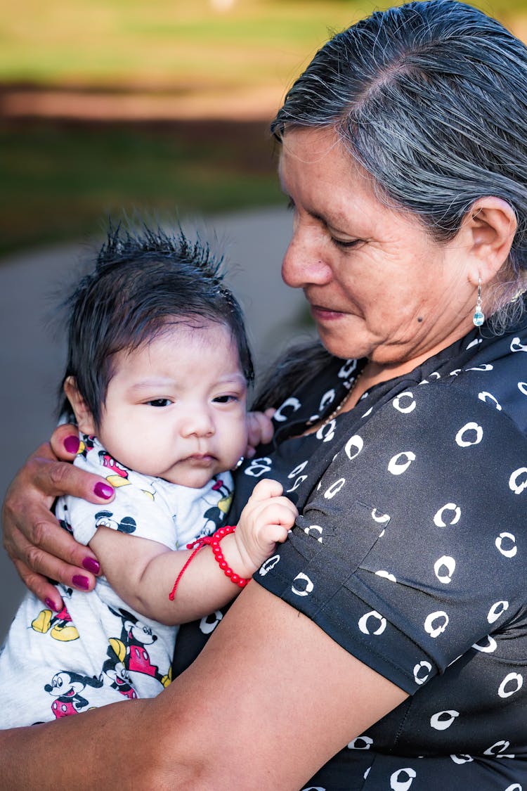 A Woman Carrying Her Grandchild 