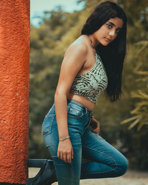 A Woman Wearing Sleeveless Crop top and Denim Jeans