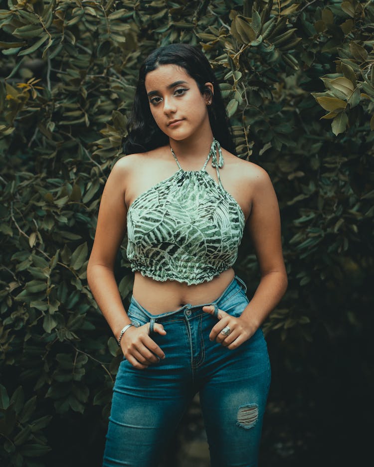 Young Woman Posing In Printed Halter Crop Top And Denim Pants