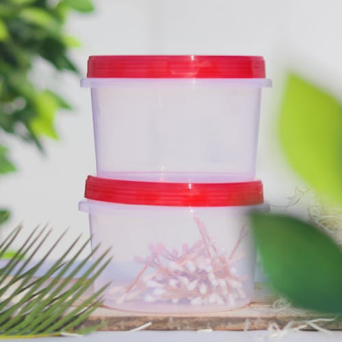 A Cotton Buds Inside the Plastic Container with Red Lids