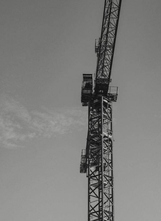 Grayscale Photo of a Tower Crane · Free Stock Photo