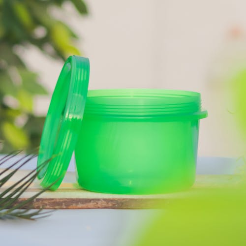 A Green Plastic Container on a Wooden Board