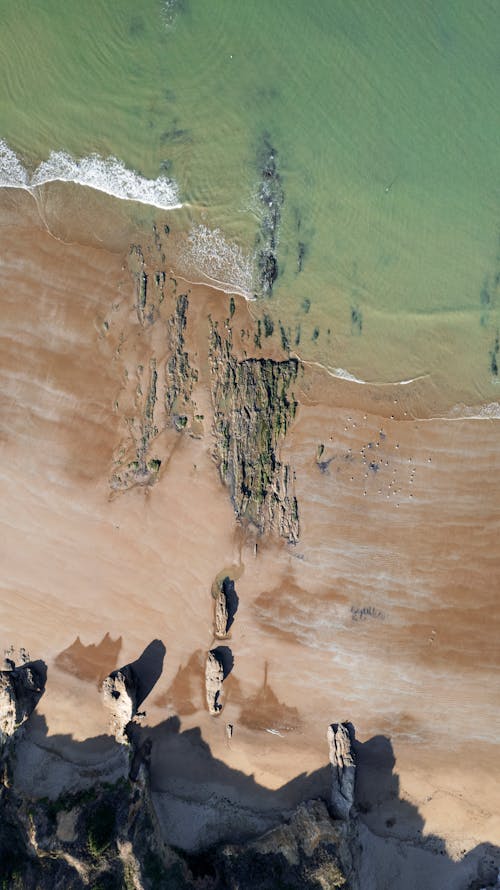 Aerial View of Rocks among Sand on Beach
