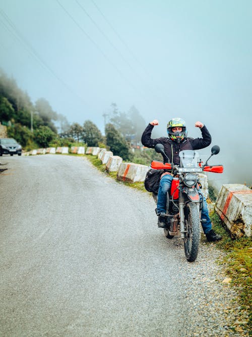 A Man Sitting on a Motorcycle Parked on the Road