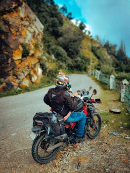 Biker takes a break on a scenic mountain road, perfect for travel and adventure enthusiasts.