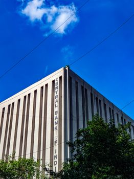 Geometric architecture of Central Bank of India against a bright blue sky.