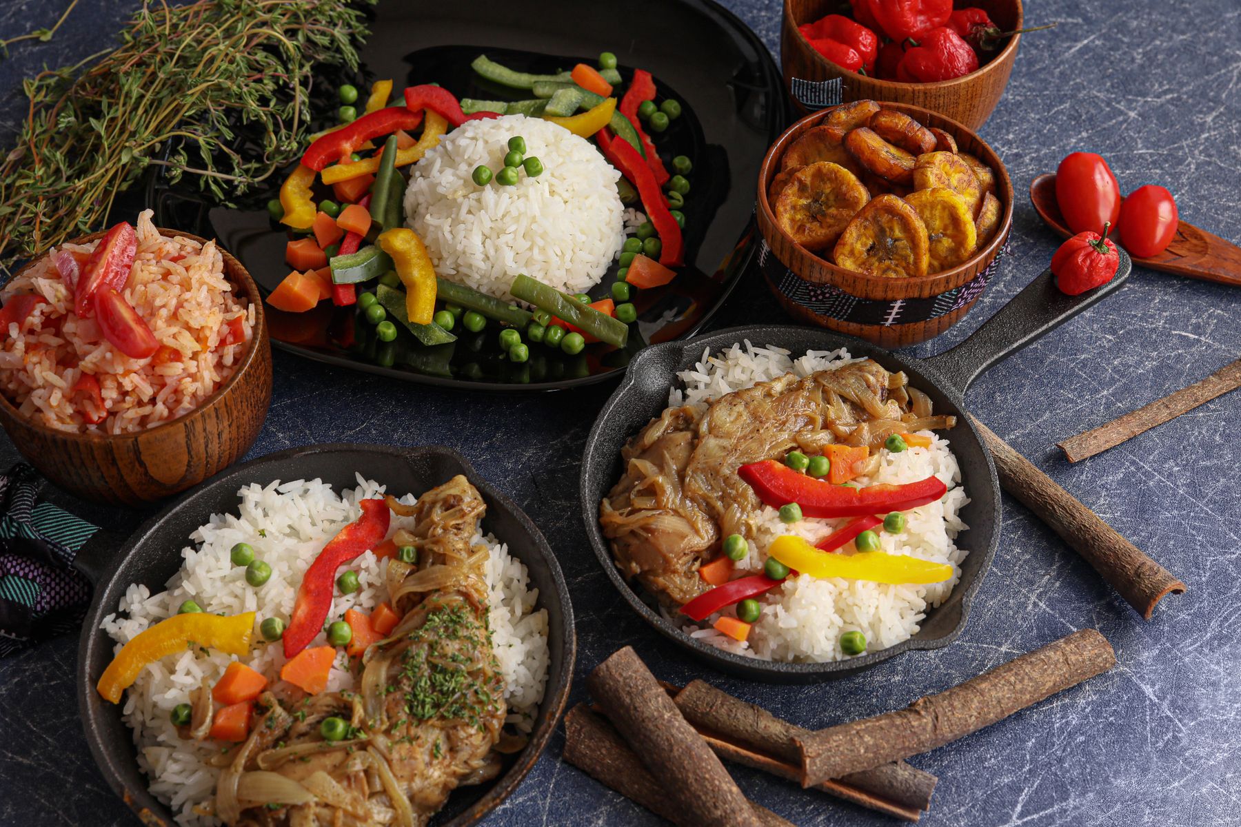 Assorted Nigerian rice dishes with plantain, meat and stew