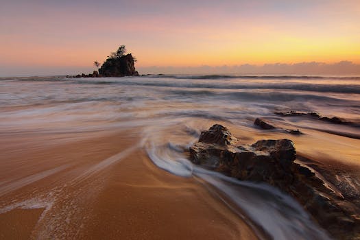 日出时分，海浪拍打着岩石，宁静的海滩场景捕捉到了大自然的美丽