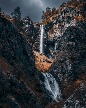 Waterfalls on Rocky Mountain Under Cloudy Sky