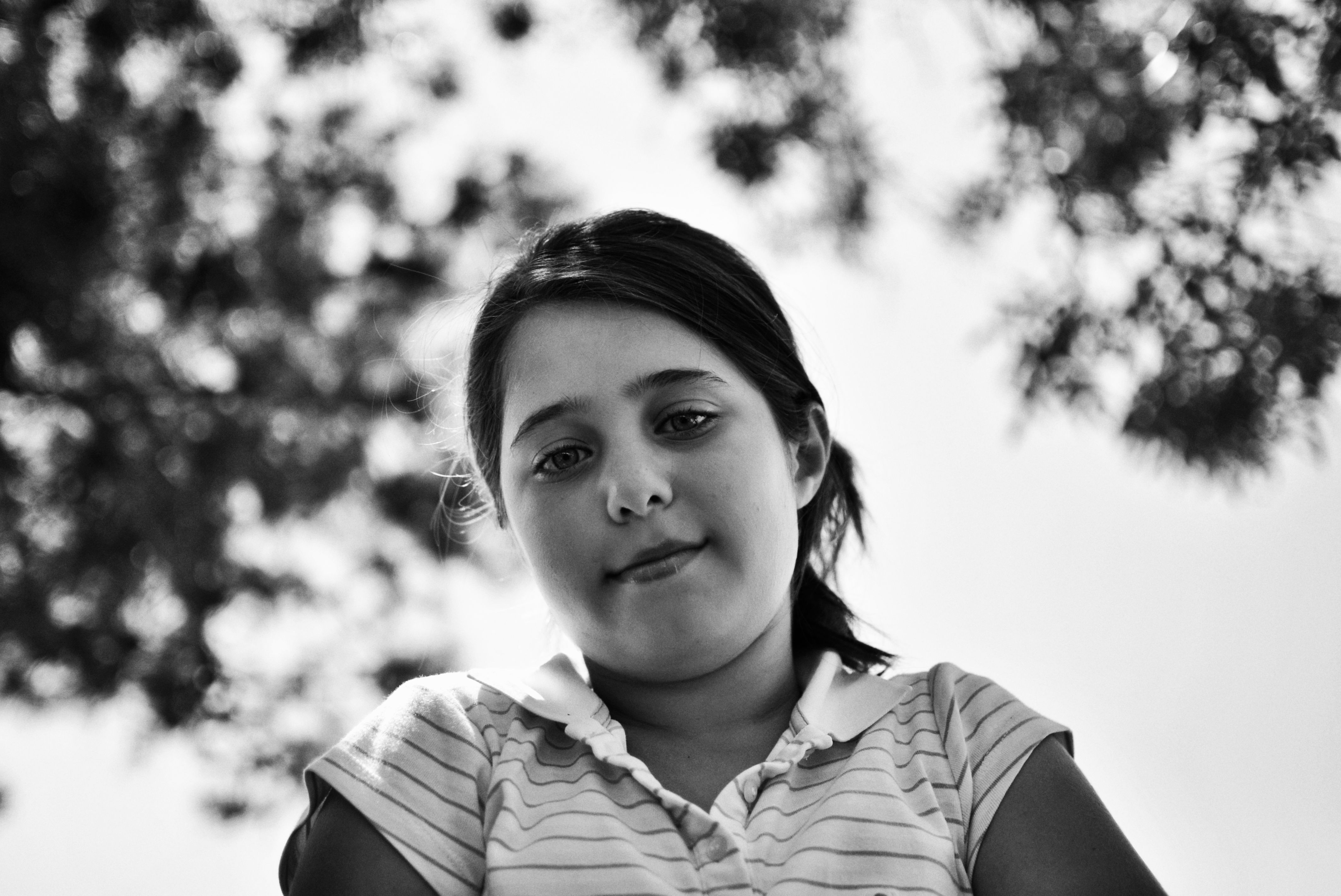 Black and White Portrait of a Smiling Girl Outdoors · Free Stock Photo