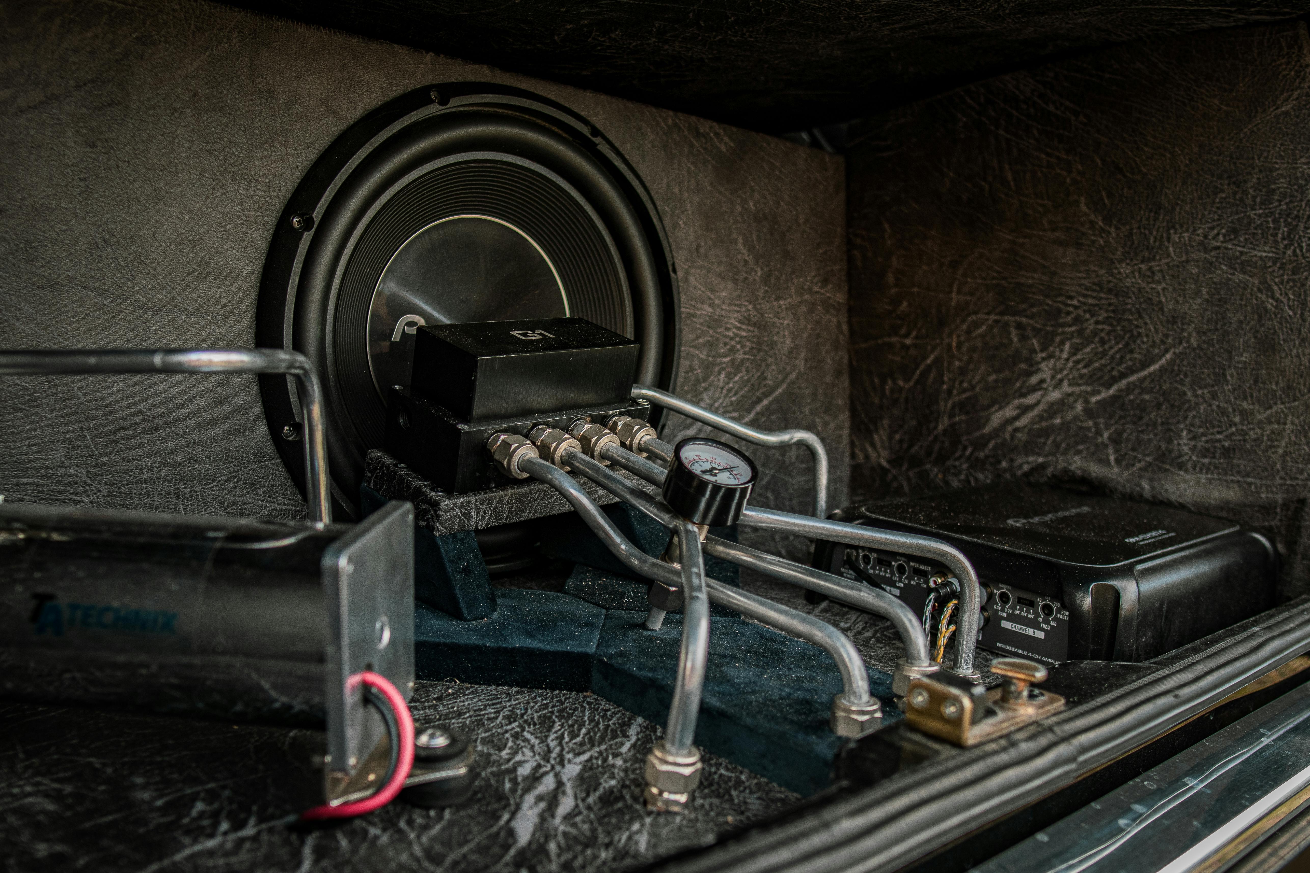 Close-up of an intricate car audio and hydraulic setup with metal components.