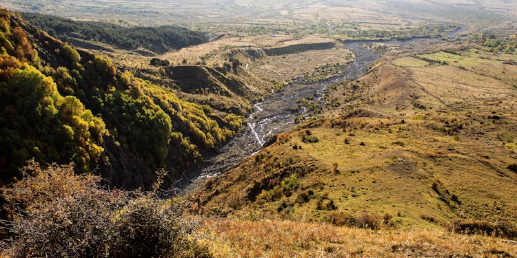 River Flowing In Green Valley In Mountains Landscape