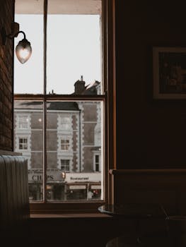 Warm, inviting café interior with window view of town buildings.