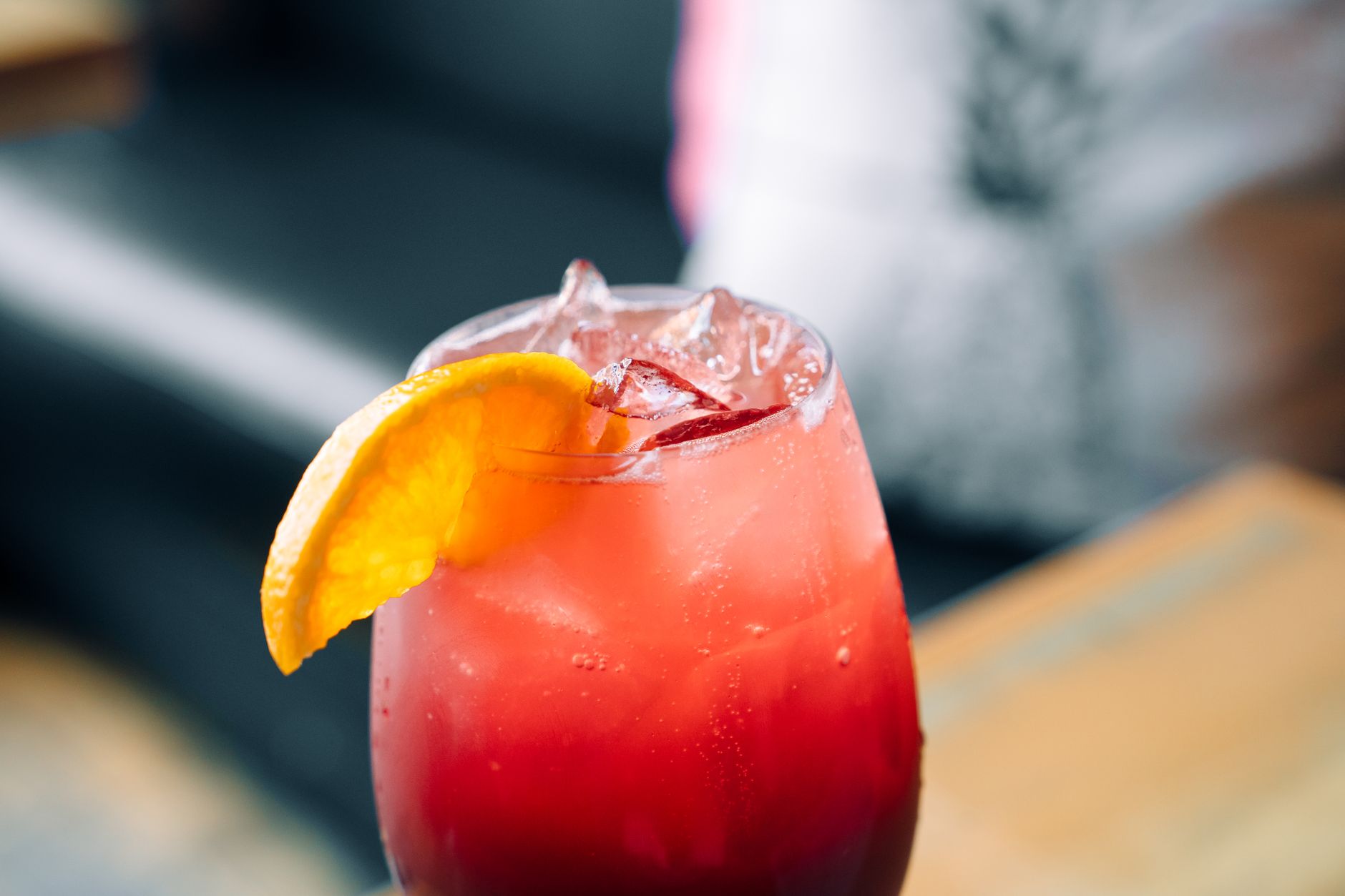 Pouring sparkling sangria into glass with fresh fruit garnish