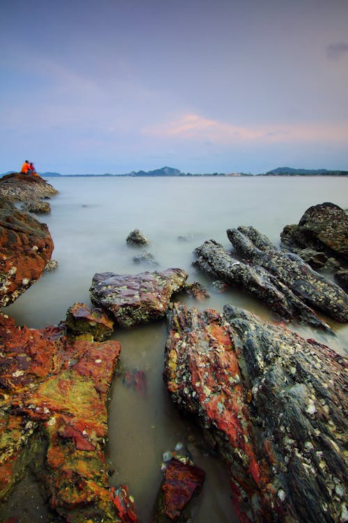 Grey and Brown Stone and Boulders Surrounded by Body of Water