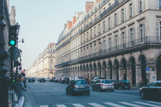 A busy street in Paris showcasing classic architecture and lively urban traffic.