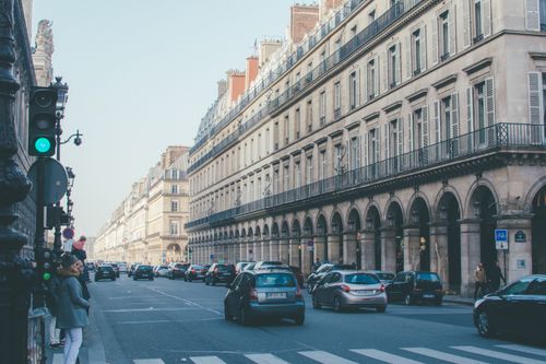 Free A busy street in Paris showcasing classic architecture and lively urban traffic. Stock Photo