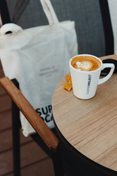 Enjoy a creamy cappuccino with latte art served on a round table at a stylish café in Ankara, Turkey.