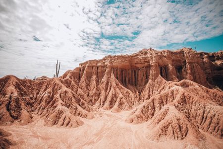 Formações vermelhas do Deserto de la Tatacoa sob céu aberto com nuvens
