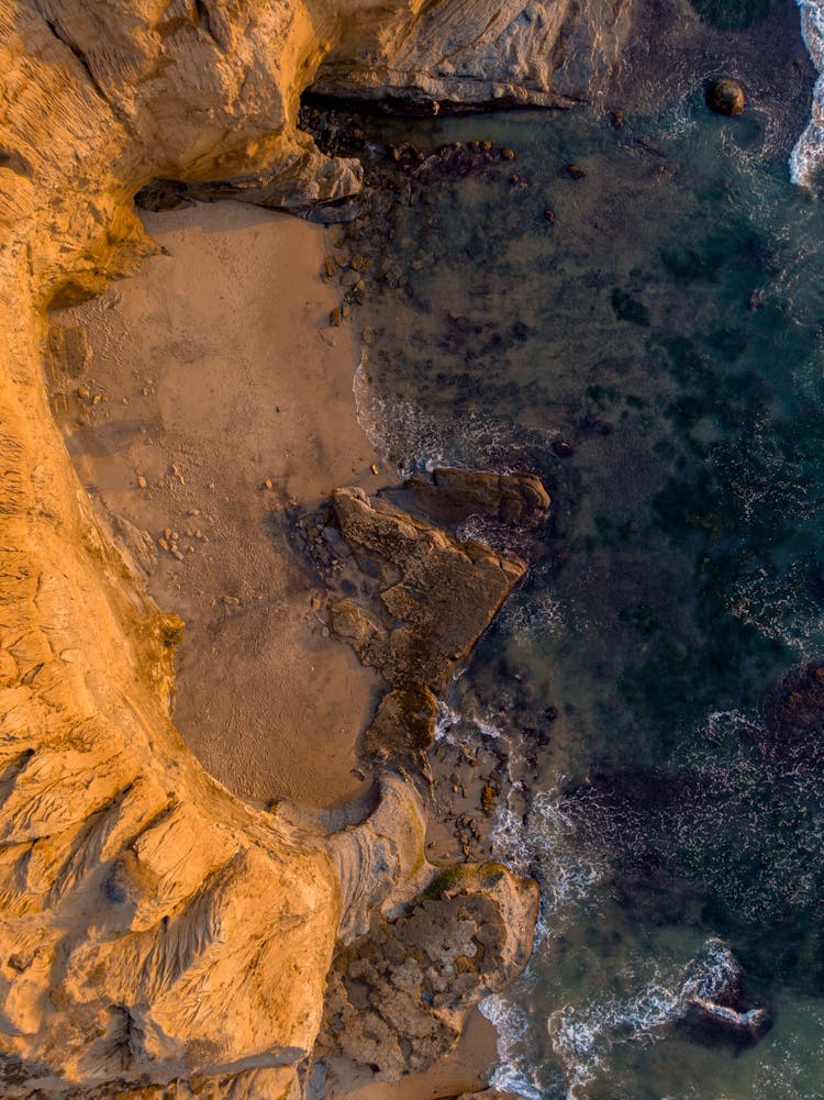 Bird's Eye View Of Brown Rock Mountain On Body Of Water