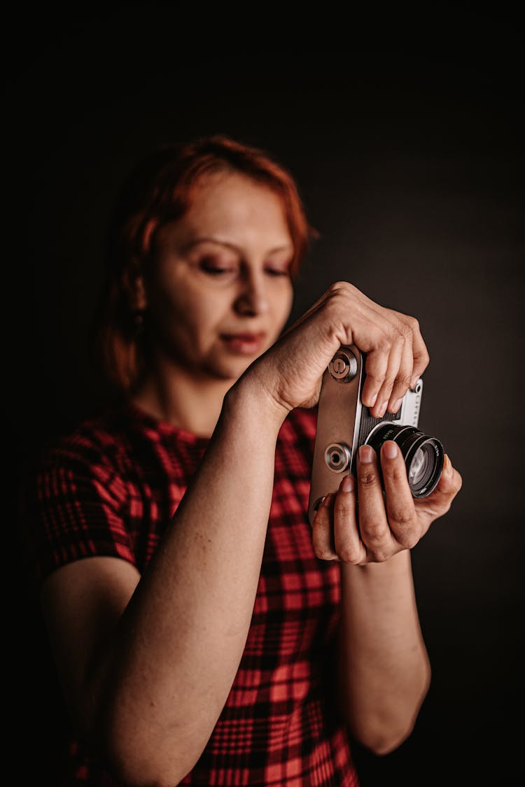 Woman In Plaid Dress Holding A Camera 