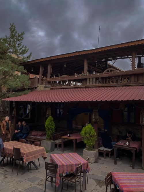Free Rustic outdoor restaurant with wooden decor under an overcast sky, inviting patrons to relax. Stock Photo