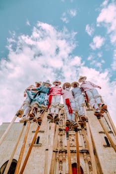 Group of performers on stilts in vibrant costumes against a historic cathedral backdrop.