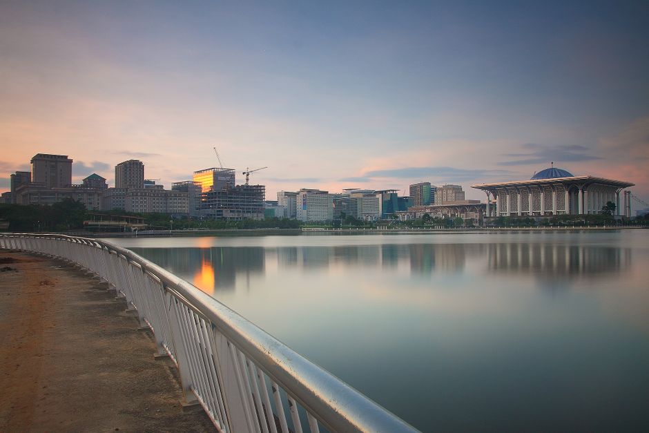 Captivating cityscape of Putrajaya at sunset with reflective waterfront view.