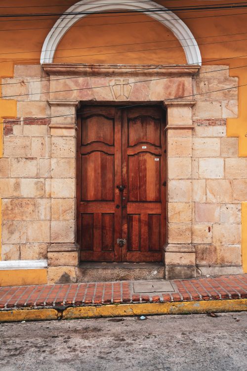 Free An inviting rustic wooden door in a historic facade in Mérida, Venezuela. Stock Photo