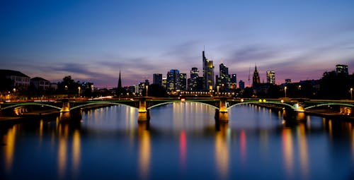 Bridge Across City Buildings during Nighttime