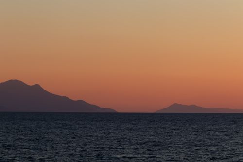 Free Tranquil sunset over the Aegean Sea with distant mountains in İzmir, Turkey. Stock Photo