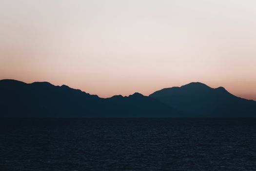 Tranquil silhouette of mountains against a colorful sunset in Izmir, Turkey.