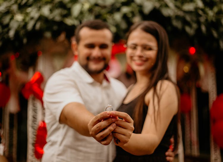 Happy Couple Showing Engagement Ring In Hands