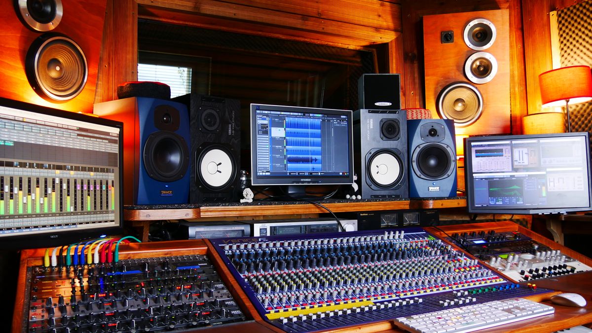 Professional recording studio with mixing console and computer screens