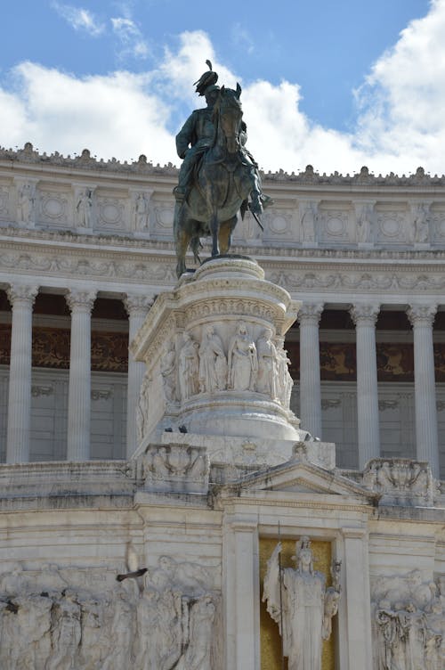 Statue of a Man Riding a Horse Near the Buildings with Intricate Carvings